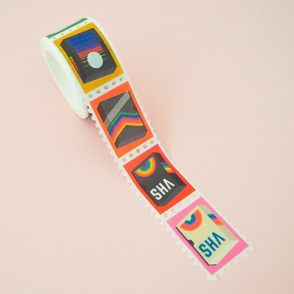 Roll of washi tape in a stamp style with perforated edges. Each stamp has a different retro VHS tape design on a colourful background.
