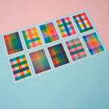 Ten stamps cut from a roll of washi tape with perforated edges. Each stamp has a different, colourful gingham-patterned design. They are arranged in two rows of five on a pale blue card.