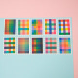 Ten stamps cut from a roll of washi tape with perforated edges. Each stamp has a different, colourful gingham-patterned design. They are arranged in two rows of five on a pale blue card.