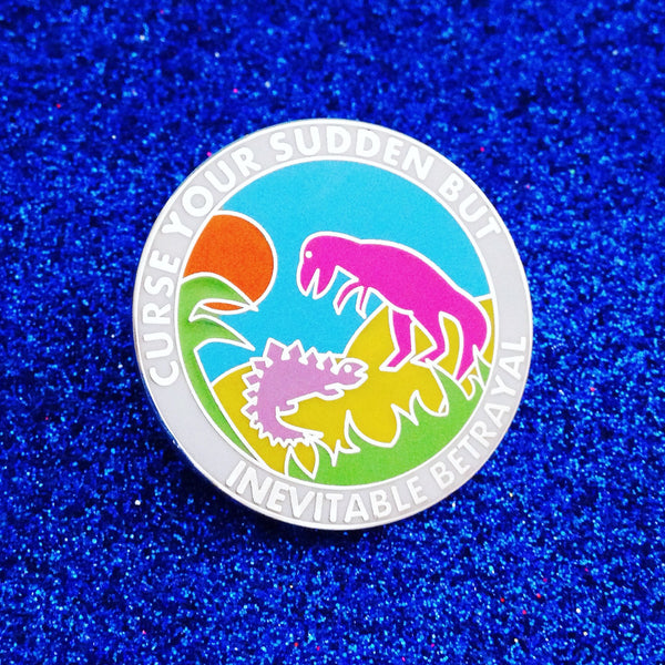 Round enamel pin with a coulourful scene depicting a t-rex looming over a stegasaurus in a leafy environment. A bright orange sun burns above them. Around the outside, in a white band, silver words read Curse Your Sudden But Inevitable Betrayal in capital letters. The pin is on a deep blue, glittery background.