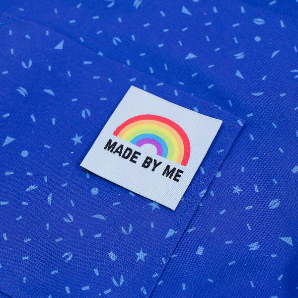 Pale blue clothing label with the words made by me in black capital letters and a bright rainbow above. Label is on bright blue material.