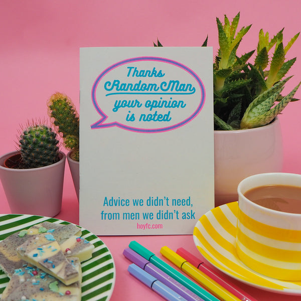 White zine with a speech bubble outlined in magenta and purple. The bubble is white and within it reads Thanks Random Man your opinion is noted in cyan script. At the bottom it reads Advice we didn't need, from men we didn't ask. The zine is surrounded by cacti, a cup of tea, and snacks.