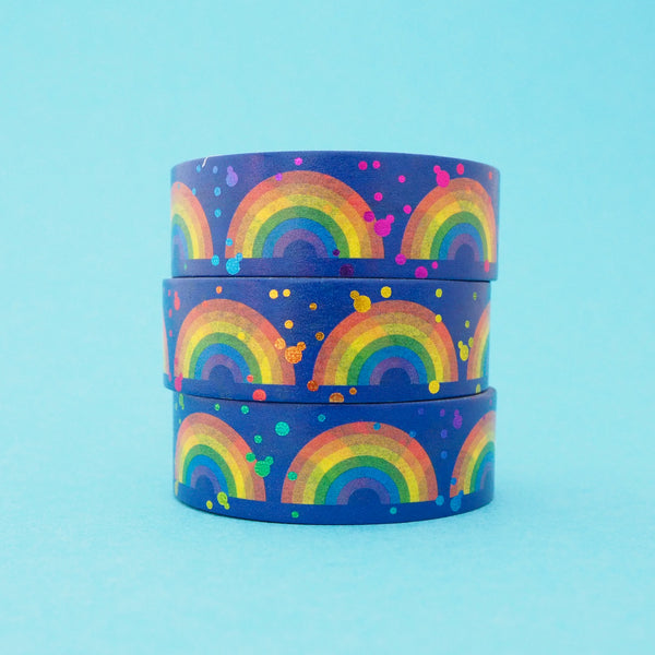 Stack of deep blue washi tape featuring rainbows and colourful foil accents.