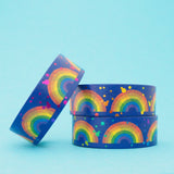 Stack of deep blue washi tape featuring rainbows and colourful foil accents.