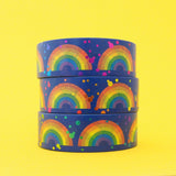 Stack of deep blue washi tape featuring rainbows and colourful foil accents.