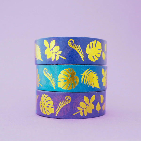 Stack of purple and blue gradient washi  tape with a variety of gold-foil plants and leaves.