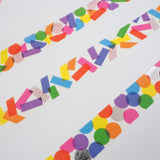 Three strips of white washi tape with a scattered design of colourful shapes. One has circles, one has rectangles. and the third has a variety of shapes. The colours change where the shapes overlap. Accented with silver foil.