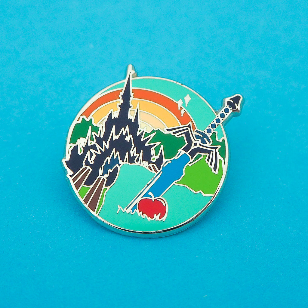 Enamel pin featuring a sword and apple in the foreground with a castle and sunrise in the background. Pin shown on a blue background.