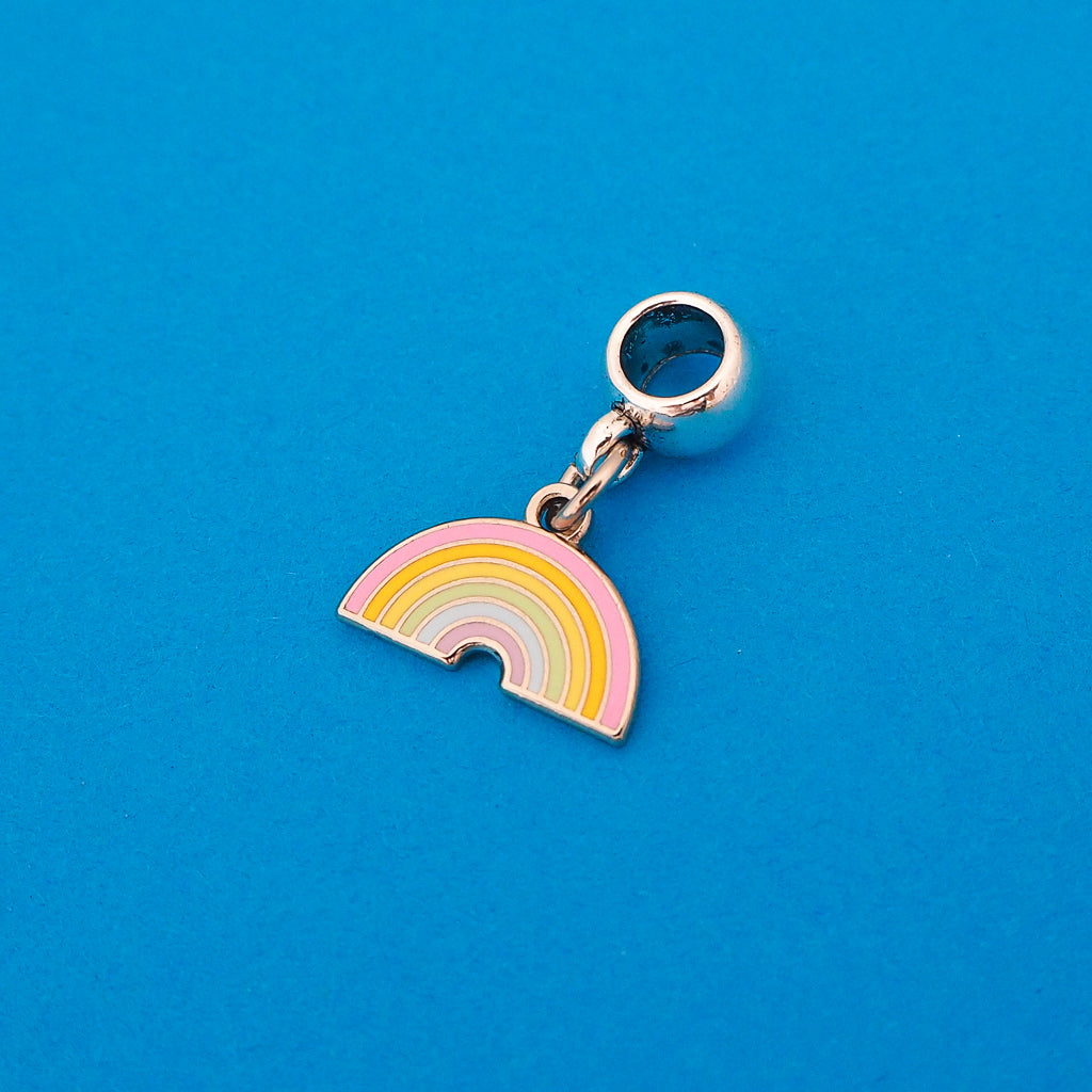 Enamel charm on a smooth cup bail bead. Charm depicts a pastel coloured rainbow.