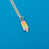 Silver-plated curb chain necklace with an enamel charm pendant. Charm is in the shape of an ice lolly. The lolly has horizontal rainbow stripes with the pastel colours dripping into neighbouring sections like it is melting.