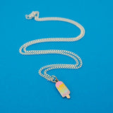 Silver-plated curb chain necklace with an enamel charm pendant. Charm is in the shape of an ice lolly. The lolly has horizontal rainbow stripes with the pastel colours dripping into neighbouring sections like it is melting.
