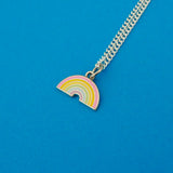 Silver-plated curb chain necklace with an enamel charm pendant. Charm depicts a pastel coloured rainbow.