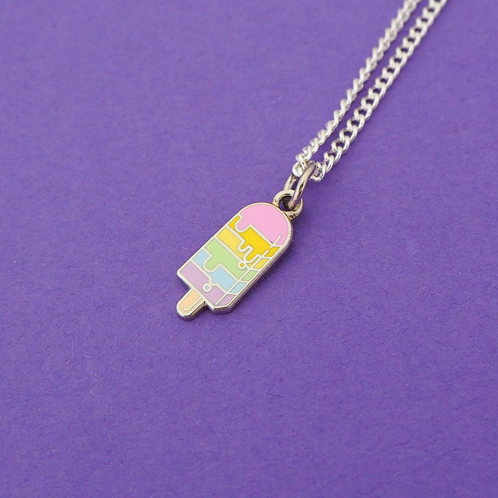 Silver-plated curb chain necklace with an enamel charm pendant. Charm is in the shape of an ice lolly. The lolly has horizontal rainbow stripes with the pastel colours dripping into neighbouring sections like it is melting.