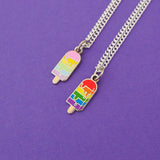 Two silver-plated curb chain necklaces with an enamel charm pendant. Charm is in the shape of an ice lolly. The lolly has horizontal rainbow stripes with the colours dripping into neighbouring sections like it is melting. One charm is brightly-coloured, the other is pastel-coloured.