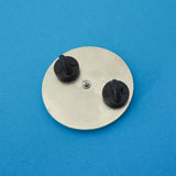 The back of a circular pin with two rubber backings.