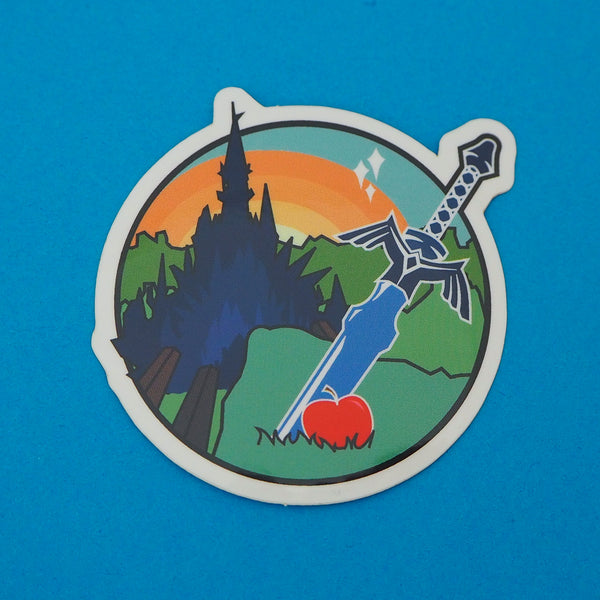 Sticker featuring a sword and apple in the foreground with a castle and sunrise in the background. Sticker has a white edge.