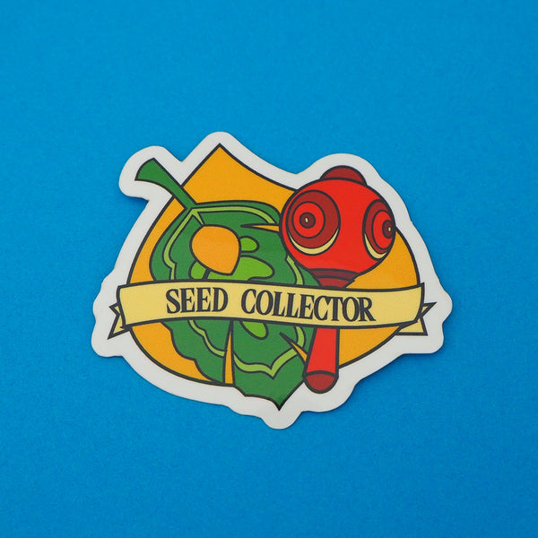 Vinyl sticker featuring a green leaf and red maraca on a korok seed background, a banner at the bottom reads Seed Collector. The sticker has a white border.